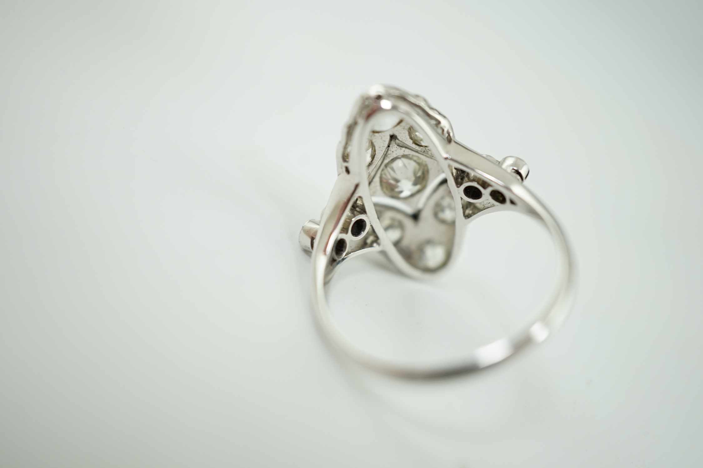An early 20th century 18ct white gold, platinum and millegrain set old cut diamond cluster ring